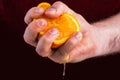 Male hand squeezing orange. Royalty Free Stock Photo