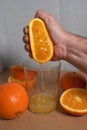 Male hand squeezing an orange into a glass Royalty Free Stock Photo