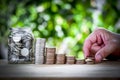 Male hand stack coins and layer to show keep money step and money in a jar Royalty Free Stock Photo