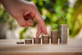 Male hand stacking coins with tree for the second step like growing for the future, education, home, loan and child. Royalty Free Stock Photo