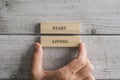 Male hand stacking two wooden blocks with a Start living sign on them