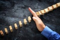 A male hand stopping the domino effect. executive and risk control concept Royalty Free Stock Photo
