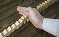 A male hand stopping the domino effect. Royalty Free Stock Photo