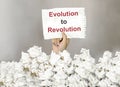 Male hand take a paper with text Evolution to Revolution with a lot of another paper Royalty Free Stock Photo