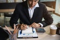 Male hand taking notes on a notebook handwritten note writing business schedule and use a laptop computer at the office desk in Royalty Free Stock Photo