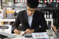 Male hand taking notes on a notebook handwritten note writing business schedule and use a laptop computer at the office desk in Royalty Free Stock Photo