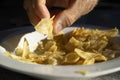 Male hand taking salted crisps from a bowl