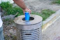 Male hand throwing a cardboard can into a metal dustbin outdoor Royalty Free Stock Photo