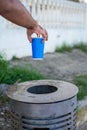 Male hand throwing a cardboard can into a metal dustbin outdoor Royalty Free Stock Photo