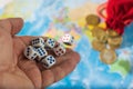 Male hand throwing dice on the table with a world map and money. The concept of ownership of the world. World order. Royalty Free Stock Photo