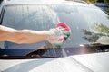 Male hand with tool for washing windows, car wash.man washing a soapy blue car with colorful sponge.Man washing car with Royalty Free Stock Photo