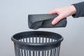 Discarding a Rolled Worn Mouse Pad into a Trash Bin