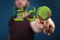 Male hand touching a 3D rendered ECO word made from grass and globe Royalty Free Stock Photo