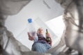 Male hand trowing a plastic bottle into a garbage bin Royalty Free Stock Photo