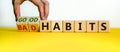 Male hand turning cubes and changes the expression `bad habits` to `good habits`. Beautiful yellow table, white background. Royalty Free Stock Photo