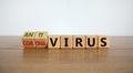 Male hand turns a cube and changes the expression `Corona Virus` to `Anti Virus`. Beautiful wooden table, white background. Royalty Free Stock Photo