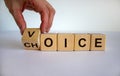 Male hand turns a cube and changes the word `voice` to `choice`. Business concept. Beautiful white background