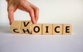 Male hand turns a cube and changes the word `voice` to `choice` or vice versa. Business concept. Beautiful white background, c