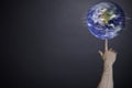 Male hand twirling a globe on a finger