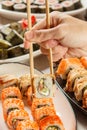 Male hand with two chopsticks holding Uramaki roll with Conger, Royalty Free Stock Photo