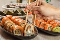 Male hand with two chopsticks holding Uramaki roll with Conger Royalty Free Stock Photo