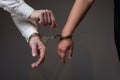 Male hand unlocking female one from handcuffs