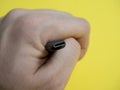 Male hand usb type C cable close-up on yellow background Royalty Free Stock Photo