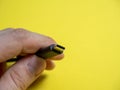 Male hand usb type C cable close-up on yellow background. Copy space Royalty Free Stock Photo