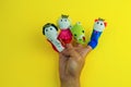 hand wearing 4 finger puppets - king,prince,princess and dragon