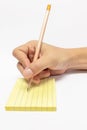 Male Hand with Wooden Pencil Writing in Yellow Sticky Notebook with Line Royalty Free Stock Photo