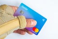 Male hand with a wrist brace holding a Revolut card. Revolut Ltd offers pay-per-day medical insurance for their customers.