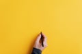 Male hand writing on a blank yellow surface with black marker Royalty Free Stock Photo