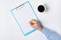 Male hand writing on paper. Top view of documents in hand and Cup of coffee. Copy space, backdrop pattern