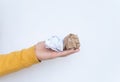 Male hand in a yellow sweater holding crumpled white and brown sheets of paper on a white background, close-up, . Paper Royalty Free Stock Photo