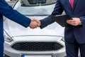 Male hands against car, making handshakes close up