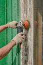 Male hands with an angle grinder clean the old wooden window frame of paint. Royalty Free Stock Photo