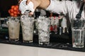 Male hands of the bartender close-up, makes a cocktail on the bar, glasses with ice Royalty Free Stock Photo