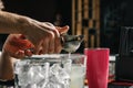 Male hands of the bartender close-up, makes a cocktail on the bar, glasses with ice Royalty Free Stock Photo