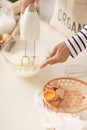 Male hands beating egg whites cream with mixer in the bowl