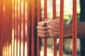 Male hands behind prison yard bars Royalty Free Stock Photo