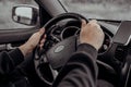 Male hands on black steering wheel of modern car. Automobile saloon. Driving on road concept.