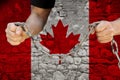 Male hands break the iron chain, a symbol of bondage,protest against the background of the national flag of Canada, the concept of Royalty Free Stock Photo
