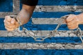 Male hands break the iron chain, a symbol of bondage,protest against the background of the national flag of Greece, the concept of