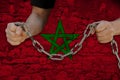 Male hands break the iron chain, a symbol of bondage,protest against the background of the national flag Morocco, the concept of