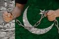 Male Hands Breaking The Iron Chain, Symbol Of Bondage, Protest Against The Background Of The State Flag Of Pakistan, The Concept