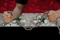 Male hands breaking the iron chain, symbol of bondage, protest against the background of the state flag of Syria, the concept of