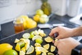 Male hands slicing lemons and limes on a black tray Royalty Free Stock Photo