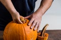 Male hands carving pumpkin taking out seeds