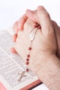 Male hands closed in prayer holding a rosary Royalty Free Stock Photo