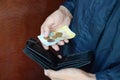 A male hands with coins with small Ukrainian bills and black old purse